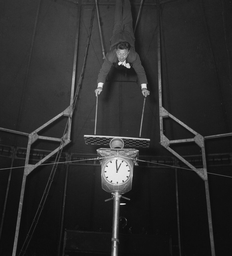 A man balancing upside down on a stack of various items.