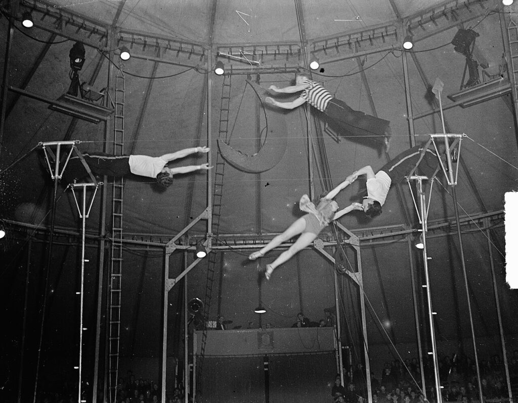 Four acrobats midair in a performance.